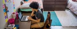 female student in dorm on laptop